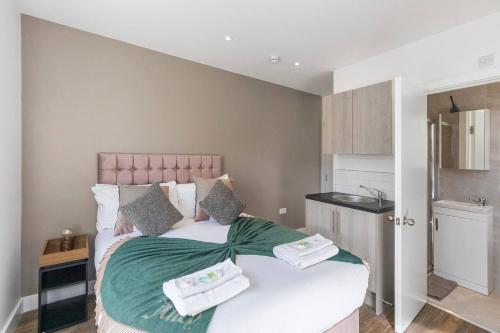 ein Schlafzimmer mit einem Bett mit zwei Handtüchern darauf in der Unterkunft The Best City Studio Near Public Transport in Ealing