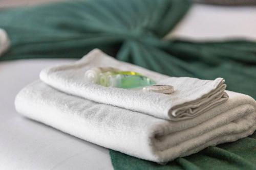 a white towel with a green glass bead on it at The Best City Studio Near Public Transport in Ealing