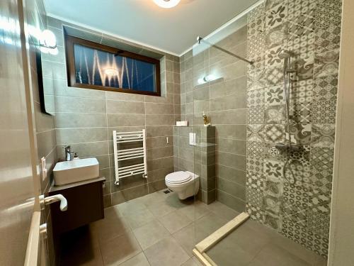 La salle de bains est pourvue de toilettes, d'un lavabo et d'une douche. dans l'établissement TURQUOISE HOUSE, à Colibiţa