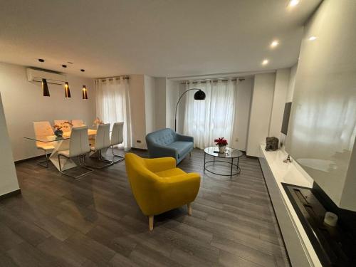 a living room with a yellow chair and a table at Increíble piso céntrico in Gandía