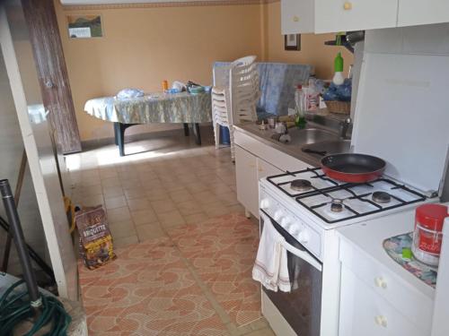 cocina con fogones, fregadero y mesa en Casa mare a 200 m, en Cosenza