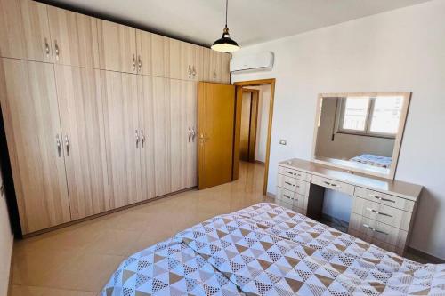 um quarto com uma cama, um toucador e um espelho. em Apartment Shkodra em Shkodër
