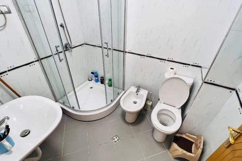 uma casa de banho com um WC, um chuveiro e um lavatório. em Apartment Shkodra em Shkodër