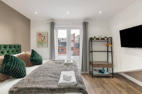 a bedroom with a large bed and a flat screen tv at Cosy Studio Perfect For Two in Hanwell