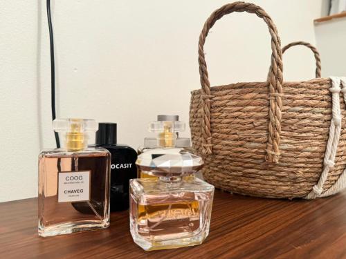una mesa con dos botellas de perfume y una cesta en Luxury private sea view room, en Abu Dabi