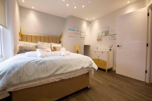 ein Schlafzimmer mit einem großen Bett und zwei Handtüchern in der Unterkunft Best Beach Side Family Flat, Central Weymouth! in Weymouth