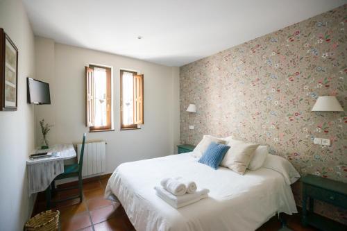 a bedroom with a bed with towels on it at La Fuentona de Ruente in Ruente