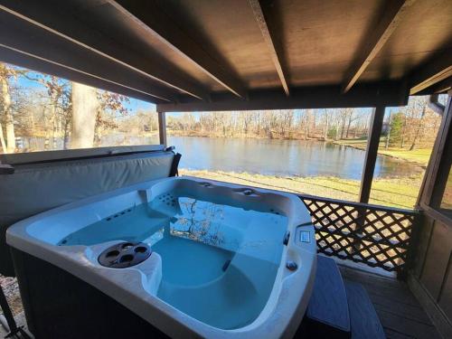a bath tub with a view of a river at Turkey Trot, Cabin Getaway on Lake w/ Hot Tub in Streetsboro