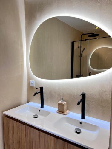 une salle de bain avec un lavabo avec un grand miroir dans l'établissement Grand Appartement ultra moderne Plein Centre, plage à pieds, avec parking, à Concarneau