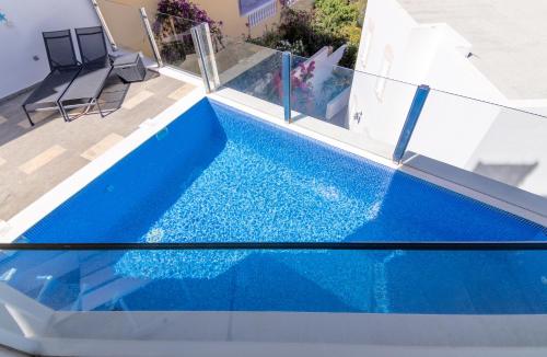 una piscina blu con due sedie accanto di Mirador Balcon del Atlantico y piscina privada ad Adeje