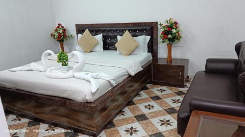 a bedroom with a bed with two swans on it at Hotel king palace madhubani in Madhubani