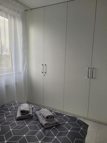 Pokój z łóżkiem z białymi szafkami i ręcznikami w obiekcie Apartament Mistral w Krakowie