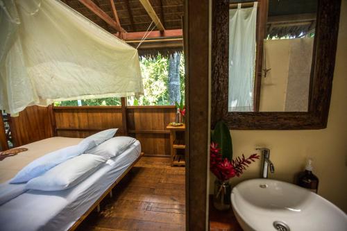 a bedroom with a bed and a tub and a sink at Hacienda Herrera Tambopata in Puerto Maldonado