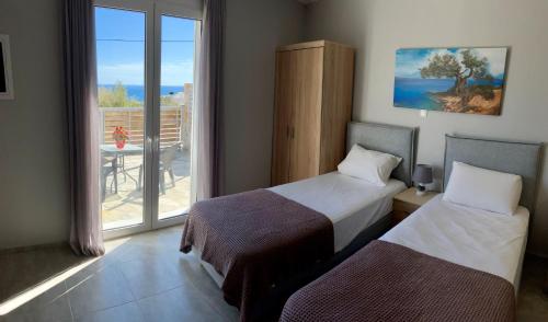 two beds in a room with a view of the ocean at Zax sea view villas in Ierápetra