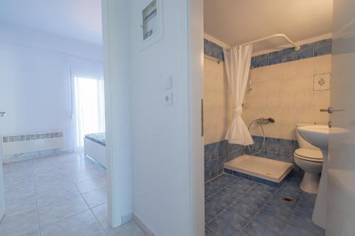 a bathroom with a toilet and a sink at 1-bedroom 500m away from the beach in Kallithea Halkidikis