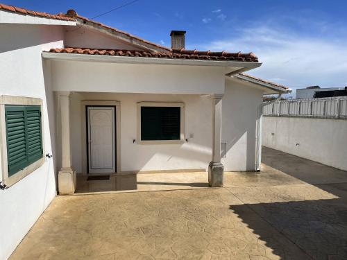 a white house with a door and a patio at Casa com Alma by LovelyStay in Fátima