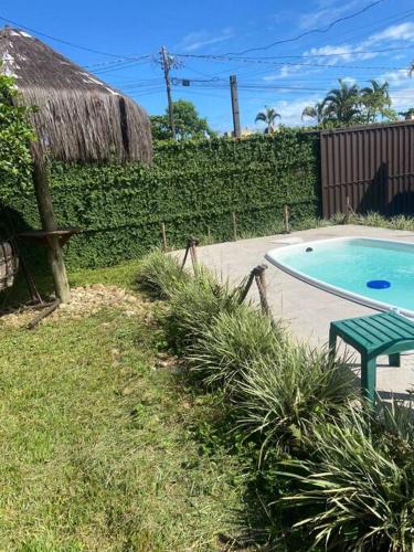 uma piscina com um banco verde ao lado de um quintal em Casa em Pontal do Paraná em Pontal do Paraná