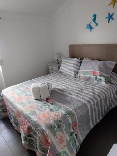 ein Schlafzimmer mit einem Bett mit einer Decke darauf in der Unterkunft Biá's House in Nazaré