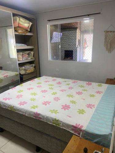 Un dormitorio con una cama con flores. en Casa em Pontal do Paraná en Pontal do Paraná