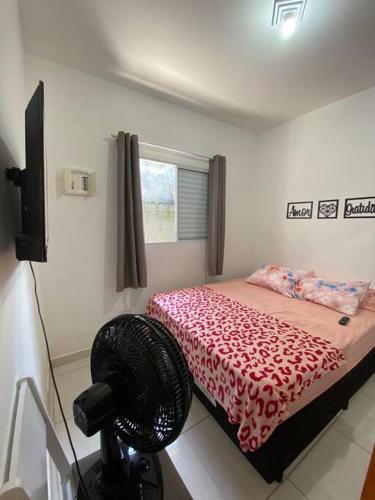 a bedroom with a bed and a fan in it at promoção novembro na praia de Itanhaém in Itanhaém
