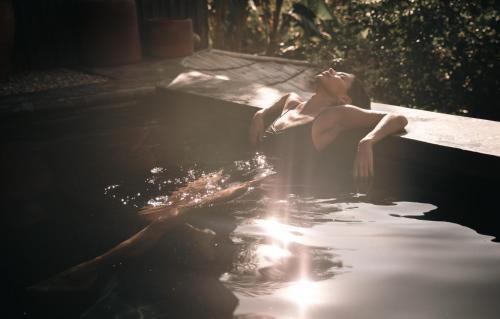 a woman is sitting in a bath tub at Ukiyo San Agustinillo in San Agustinillo