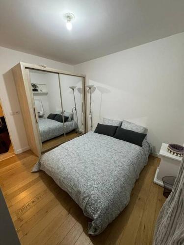une chambre avec un grand lit et un miroir dans l'établissement Elegant apartment near La Défense and Arena, à Nanterre