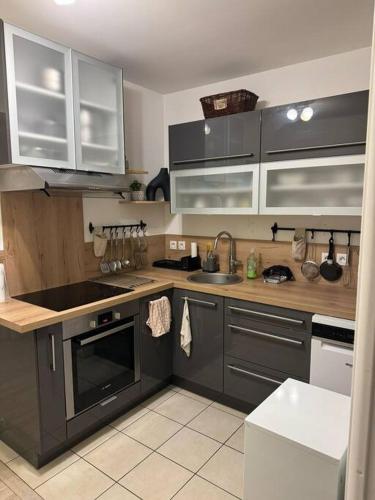 une cuisine avec des armoires grises et un évier dans l'établissement Elegant apartment near La Défense and Arena, à Nanterre