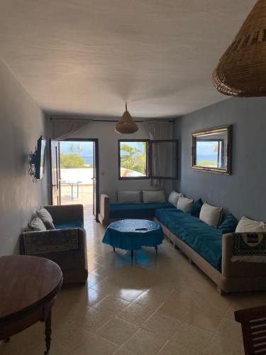 ein Wohnzimmer mit einem Sofa und einem Tisch in der Unterkunft Appartement vue sur mer Résidence Marsa M’diq in Mʼdik