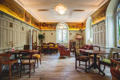 a room with tables and chairs and a piano at Auberge d'Ajoie in Porrentruy