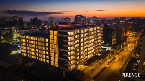 un edificio illuminato in una città di notte di Departamento Estudio, centrico a Temuco