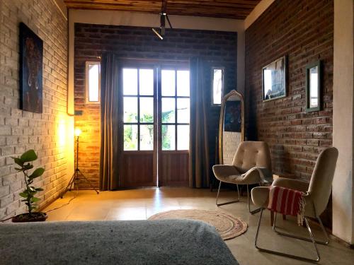 Habitación con sillas y puerta con ventana en Nativo Lodge Cabaña en Playas