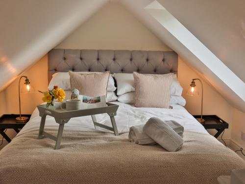 a bedroom with a large bed with a table on it at Oak Tree Hideaway in Whitchurch