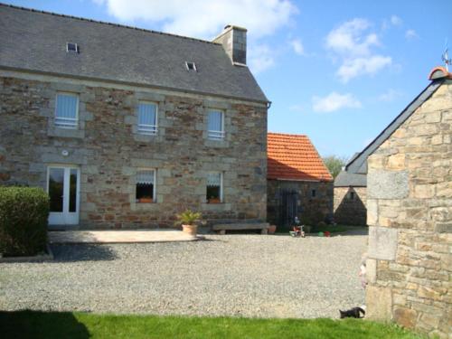 a large stone building with a dog in front of it at La route bleue in Ploumilliau