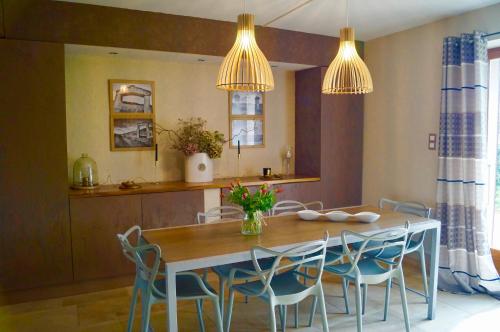 kuchnia i jadalnia ze stołem i krzesłami w obiekcie Les Prés d'Allerey 