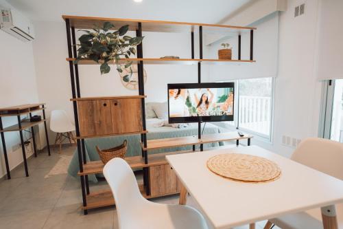 a living room with a tv and a table and chairs at MI LUGAR II Chivilcoy in Chivilcoy