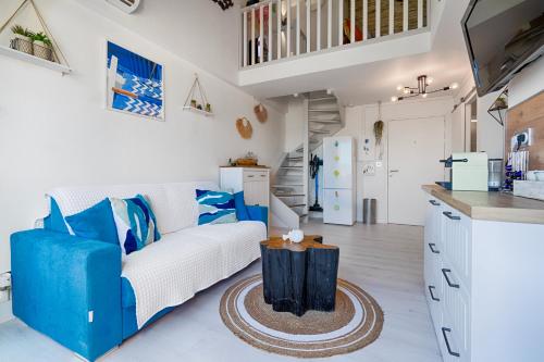 d'un salon avec un canapé blanc et des touches de bleu. dans l'établissement LA PERLE DU SUD : Classement officiel 3 étoiles + 2 Clés Clévacances, à Frontignan