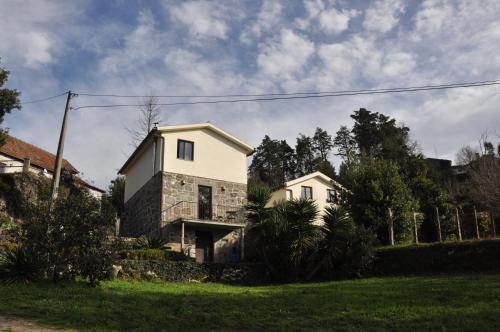 a white house in a yard with a grass field at Quinta da Encavalada in Nogueira do Cravo