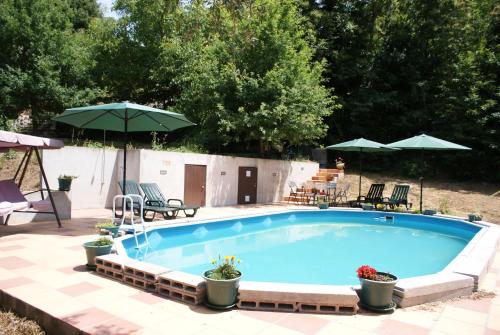 a swimming pool with umbrellas in a yard at Quinta da Encavalada in Nogueira do Cravo