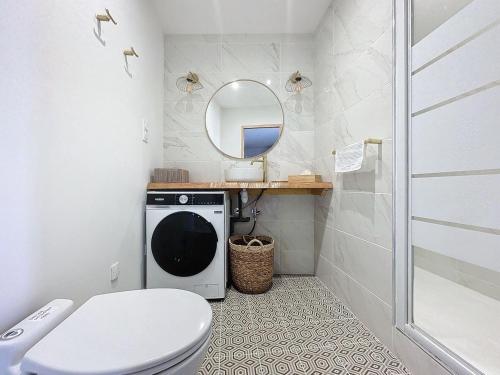W łazience znajduje się pralka i lustro. w obiekcie PARENTHESE - Bagnères-de-Bigorre w mieście Bagnères-de-Bigorre