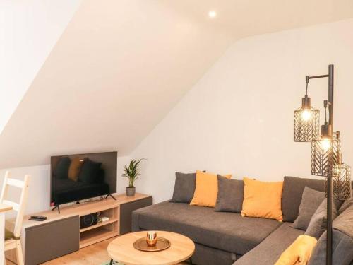a living room with a couch and a tv at Cozy seaside hideaway with free parking in Torquay