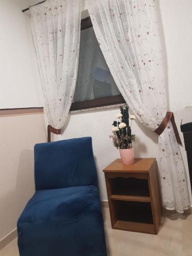 a room with a blue chair and a window at Apartment Ivan in Posušje