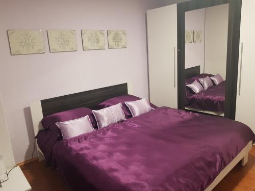 um quarto com uma cama roxa e um espelho em Apartment Ivan em Posusje