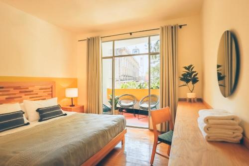 a bedroom with a bed and a large window at AirTabacalera in Mexico City