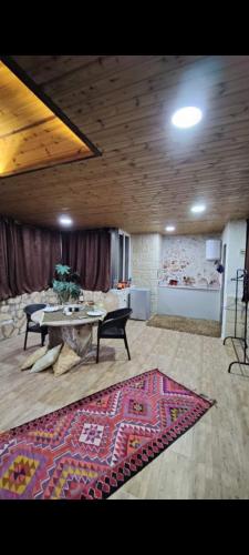 a living room with a table and a rug at Sunset Roof apartment in Madaba