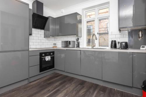 a kitchen with stainless steel appliances and wooden floors at Outstanding 2 Bed Apartment in Central Camden Sleeps 6 in London