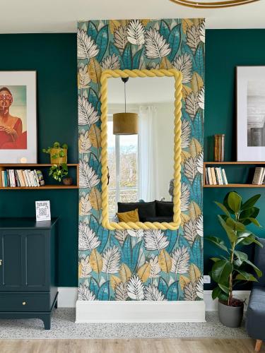 un miroir dans un salon avec un mur vert dans l'établissement Sunny Apt on D-Day Beach with Parking, à Saint-Côme-de-Fresné