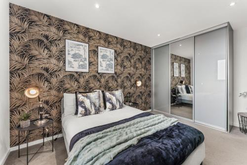 a bedroom with a bed and a wall covered in wallpaper at Beautiful Chelmsford Penthouse with Balcony in Chelmsford