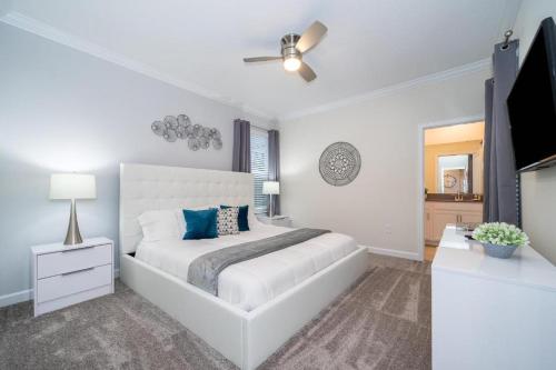 a white bedroom with a bed and a ceiling fan at Fabulous Villas 5 minutes away from Disney! in Kissimmee