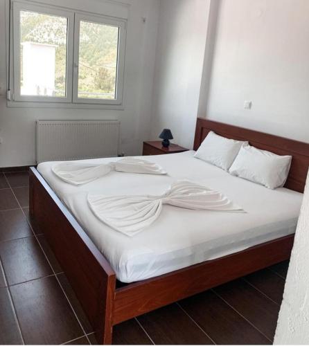 a bedroom with a large bed with white sheets at Elvi Apartment 5 in Áyios Yeóryios