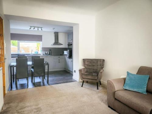 een woonkamer met een bank en een tafel met stoelen bij Central 2-bedroom bunglow with double sofa bed in Carnoustie